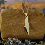 Collier tendance nommé FALESTINA posé sur un support en bois