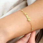 Bracelet personnalisé nommé NOUR porté autour du poignet d'une femme
