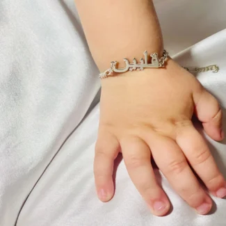 Bracelet personnalisé nommé AURORA porté autour du poignet d'un enfant